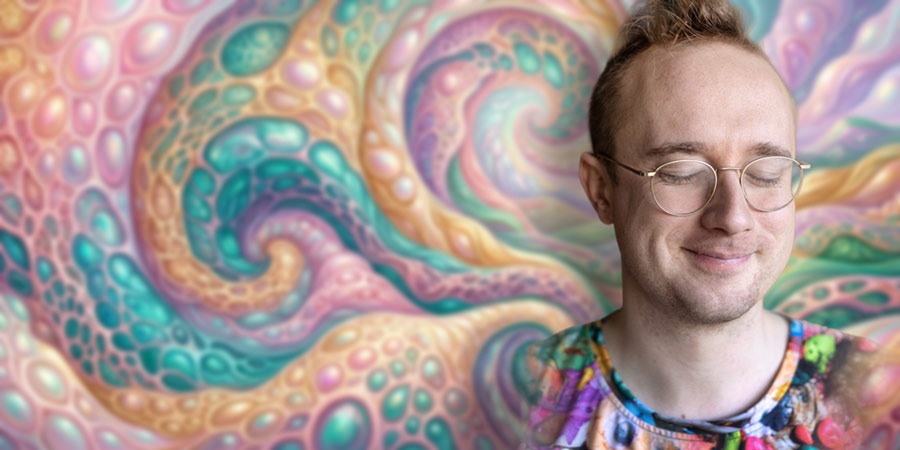 Alex Paxton mit geschlossenen Augen, Brille und buntem T-Shirt im Vordergrund rechts. Im Hintergrund farbige organische Formen mit geschwungenen Linien und schimmernden Oberflächen. Rosa, Türkis, Gold und Grün überlagern sich in abstrakter Landschaft.