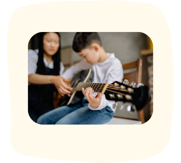 Junge mit Gitarre und Lehrerin