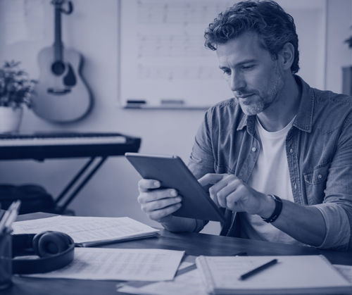 music teacher scrolling on a tablet at his desk
